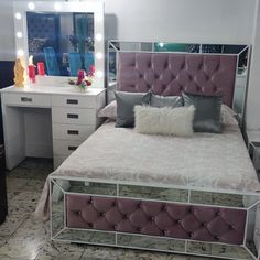 a bedroom with a bed, dressers and mirror in it's center area