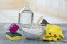 a table topped with cleaning supplies next to a bottle of water and a sponge on top of it