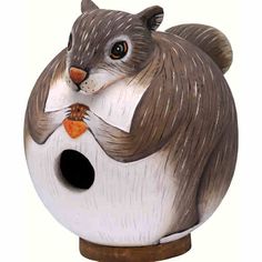 a ceramic squirrel holding a carrot in its mouth