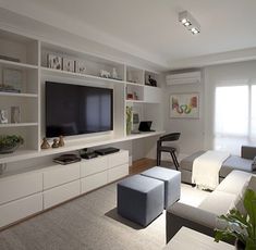 a living room filled with furniture and a flat screen tv on top of a wall