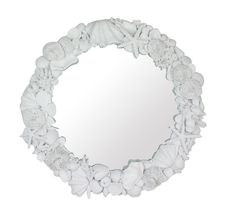 a white circular mirror with seashells on it