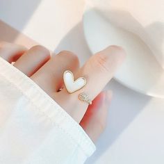 Stunning natural freshwater mother of pearl/shell statement cocktail ring, cute heart shaped signet, paved with zircon. Open and adjustable, easy to wear. Love & ocean theme, super unique and creative, elevate your dainty vibes. Perfect gift to treat yourself and your friends/family, you will get lots of compliments for sure! ♥ All of our jewelry are carefully handmade with delicate and exquisite details, all designed and made in Manhattan, New York. 💎 Features: ♥ Material: gold plated cooper ♥ Main stone: freshwater shell, mother of pearl ♥ Open adjustable size, fit US 4-9 ♥ Lightweight, easy to wear ♥ Nickel/Lead Free, Hypoallergenic 💎 Packing & Shipping: ♥ All our jewelry will be shipped with beautiful gift wrap packaging ♥ Handwrite gift notes/cards available upon request ♥ SAME DAY Dainty White Adjustable Heart Ring, White Heart Ring For Gift, Trendy White Jewelry For Valentine's Day, Dainty White Heart Ring For Gift, Dainty White Heart Ring Gift, Dainty White Heart Ring As Gift, Adjustable White Heart Ring, Minimalist White Heart Ring For Gift, Trendy White Rings For Anniversary