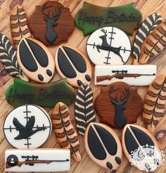 decorated cookies with hunting theme and happy birthday written on the top, sitting on a wooden surface