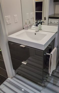 a white sink sitting under a bathroom mirror