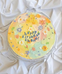 a birthday cake with the words happy birthday written in frosting and flowers on it