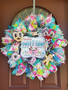 the front door wreath is decorated with colorful ribbons and bows, which reads sweet shop