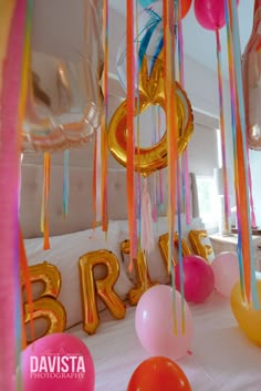 balloons and streamers are hanging from the ceiling at a bridal party with large letters