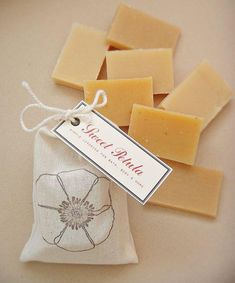 several pieces of soap sitting on top of a white cloth bag next to a tag