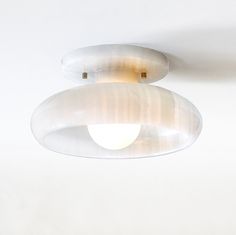 two circular lights hanging from the ceiling in a room with white walls and flooring