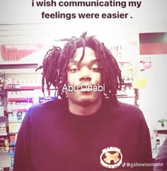 a man with dreadlocks is standing in front of a sign that says, i wish communicating my feelings were easier