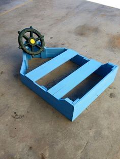 a boat's wheel on top of a blue crate