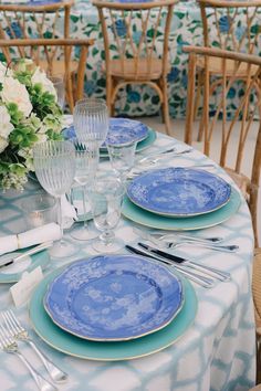 the table is set with blue plates and silverware