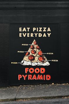 a sign on the side of a building advertising food pyramid pizzas and other foods