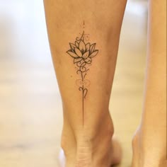 a woman's foot with a lotus tattoo on the lower part of her leg