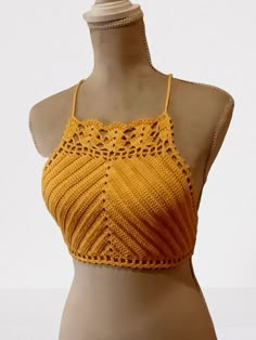 a mannequin wearing a yellow crochet top