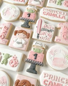 some cookies that are on top of a white table with pink and green icing