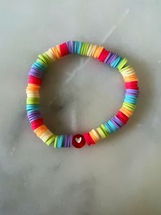 Love love love!  This rainbow heart Heishi bracelet is sure to bring joy to your wrist!  Cute as can be on its own or stacked with others!   This bracelet is made with love and is available for customization with your favorite colors and phrases, names or initials. Beads are made of Heishi clay and are environmentally friendly. Bracelets are $4 each or $15 for a stack of 5.  Please message me for orders of multiple bracelets. Sizing as follows: Child/Small teen : 6" Adult S : 6.5" Adult M : 6.75 Rainbow Heishi Bracelet, Rainbow Heishi Beads Friendship Bracelet, Rainbow Clay Bead Bracelet, Playful Rainbow Beaded Bracelets, Preppy Rainbow, Lgbtq Clay Bead Bracelet, Bracelet Heishi, Clay Beads Bracelet, Bracelets Preppy