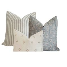 three pillows with different patterns on them, one blue and the other white in color