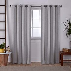 a living room with a ladder next to a window covered in gray curtains and a potted plant