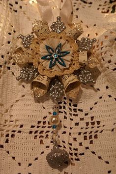 an ornament is hanging on a white lace tablecloth with beads and bows