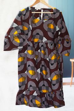 This brightly colored and boldly patterned dress is the original design of Ghana's Lydia Mawuenya Amedzrator. Crafted from 100% cotton in shades of copper, brown, and black, the dress features short flared sleeves, a round neck, and full skirt that hits at the knee. The back has a buttoned keyhole closure. Brown Cotton Midi Dress For Fall, Fall Cotton Midi Dress In Brown, Copper Brown, Knee Length Shorts, Patterned Dress, Design Gallery, Full Skirt, Flared Sleeves, Cotton Dress