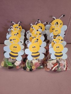 a bunch of little bees sitting on top of some gummy bags filled with candies