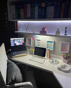 a white desk with a laptop computer on top of it next to a book shelf filled with books