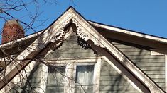 the top of a house with a clock on it's face and window sill