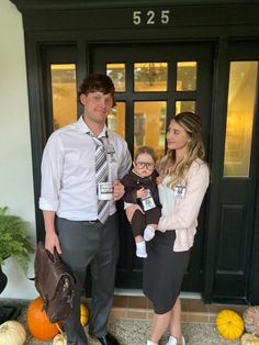 a man, woman and child standing in front of a door