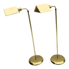 pair of brass plated floor lamps on white background