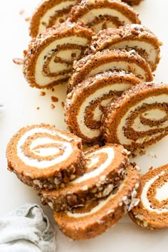 several pieces of cinnamon roll on a white plate with powdered sugar and chocolate sprinkles