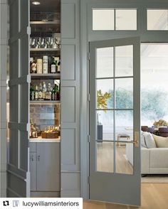 an open door leading to a living room and dining room area with wood flooring