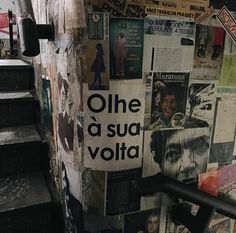 the stairs are covered with newspaper and posters on it's wall, which reads one a su volita