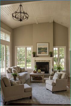 a living room with couches, chairs and a fire place in the middle of it