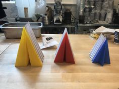 three different colored papers sitting on top of a wooden table