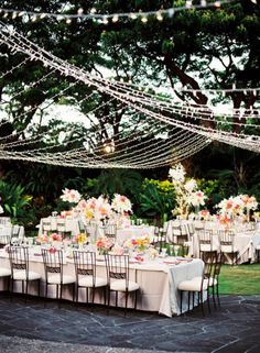 an outdoor dining area with tables and chairs set up for a formal dinner or party