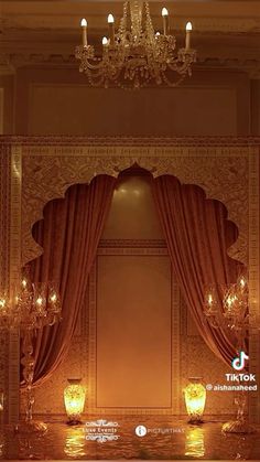 an ornate room with chandelier, candles and curtains on the windowsills