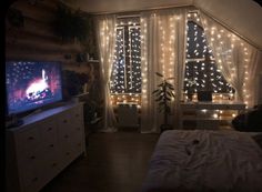 a bedroom with lights on the walls and a bed in front of a tv set