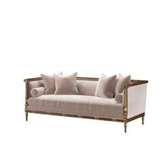 a couch with pillows on it sitting in front of a white background and gold trimmings