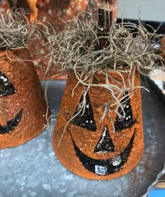 two pumpkin shaped vases decorated with black glitter and twine sprinkles