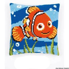 an orange clown fish pillow with green grass and blue sky in the background on a white surface