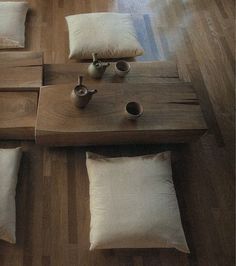 a wooden table topped with lots of pillows