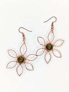 Handmade green Peridot earrings wrapped with tarnish-resistant copper. Wire wrap flower design. Green Peridot Known as the extremem gem, this crystal is associated with the sun. Peridot has been prized since the earliest civilizations for its protective powers to drive away the forces of darkness. Peridot is also highly beneficial for attuning to and regulating the cycles of one’s life Chakra: Heart | Astrology: Virgo, Leo, Scorpio | Numerology: 5, 6 | Planet: Venus | Element : Earth **Crystals Adjustable Copper Flower Earrings, Adjustable Copper Flower Jewelry, Adjustable Flower-shaped Nature-inspired Earrings, Nature-inspired Flower Jewelry With Ear Wire, Nature-inspired Flower Shape Jewelry With Ear Wire, Unique Copper Flower Jewelry, Nature-inspired Adjustable Flower Earrings, Nature-inspired Flower Shaped Ear Wire Jewelry, Green Wire Wrapped Metal Earrings