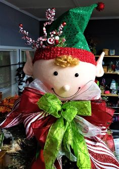 a christmas decoration with a doll wearing a green and red hat