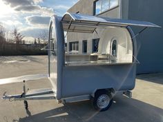 an outdoor food cart parked in front of a building with the sun shining on it