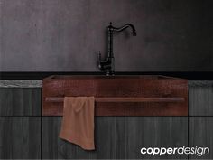 a brown sink sitting under a faucet on top of a wooden countertop