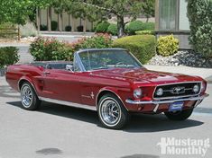 an old red mustang convertible parked in front of a house