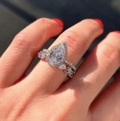 a woman's hand with a ring on it and two diamonds in the middle