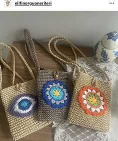 three crocheted purses are sitting on a table