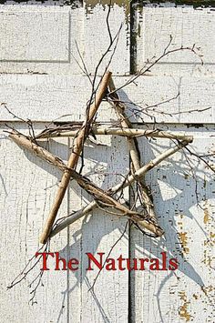 a star made out of branches on top of a white door with the words, the naturals written below it